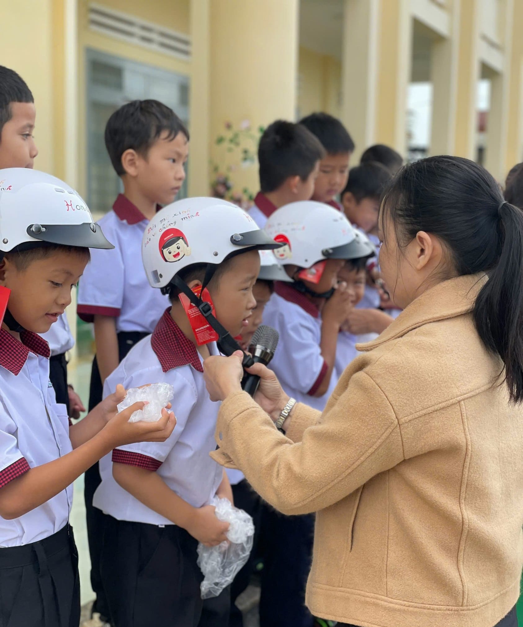 Các em học sinh phấn khởi khi nhận mũ bảo hiểm